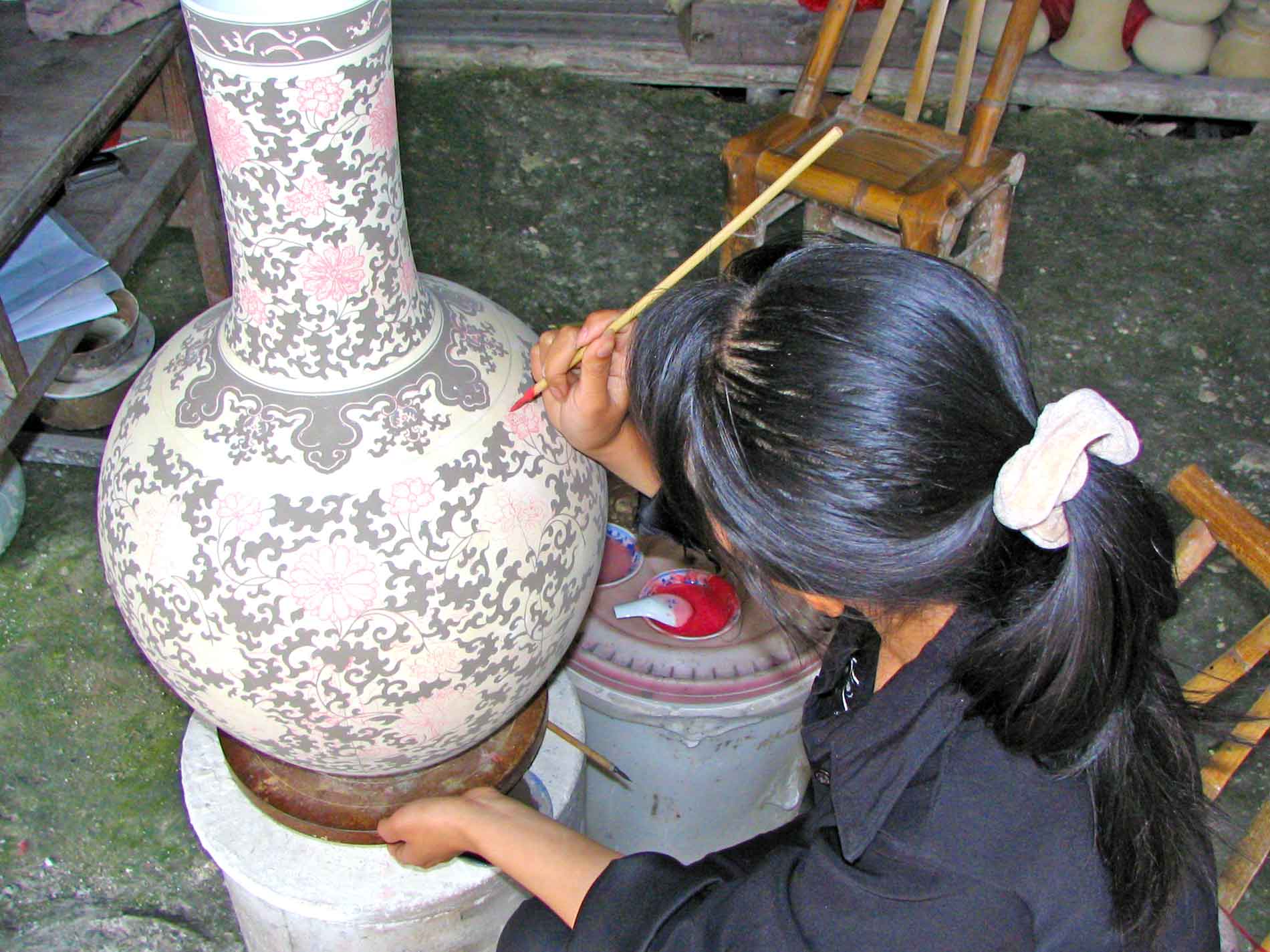 Woman Hand-Painting a Ceramic Jar in Jiujiang